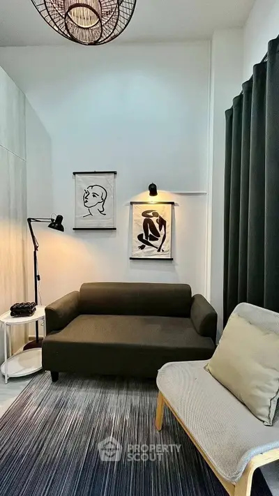 Cozy living room with modern decor, featuring a stylish sofa, artistic wall hangings, and ambient lighting.