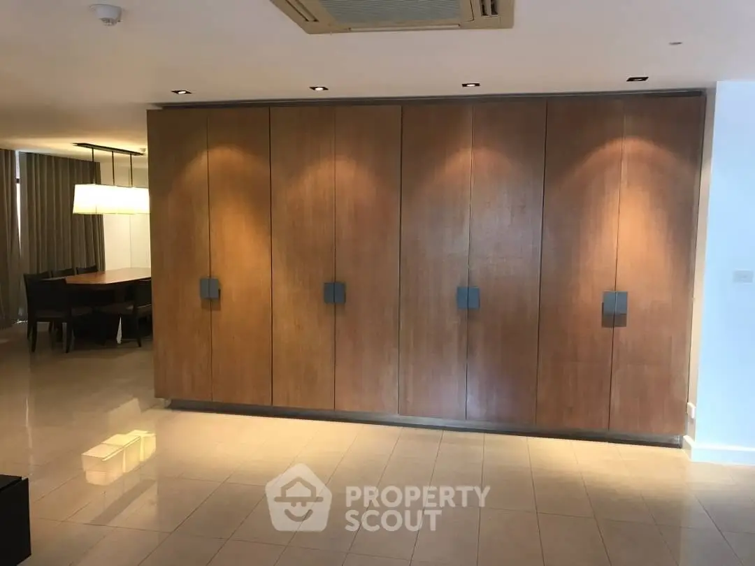 Spacious modern living room with elegant wooden paneling and dining area.