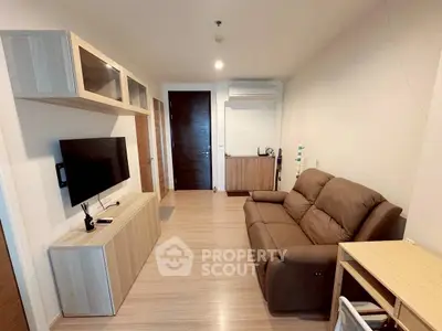 Modern living room with sleek furniture and wall-mounted TV in cozy apartment.