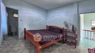 Cozy bedroom with ensuite bathroom and wooden bed frame in a serene setting.