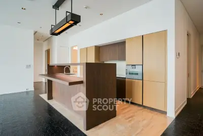 Modern kitchen with sleek wooden cabinetry and open layout in luxury apartment.