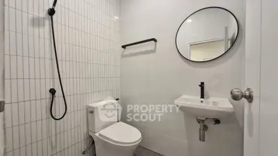Modern minimalist bathroom with sleek fixtures and round mirror