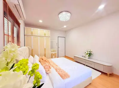 Luxurious bedroom with elegant decor and ample natural light, featuring a plush bed and stylish wardrobe.