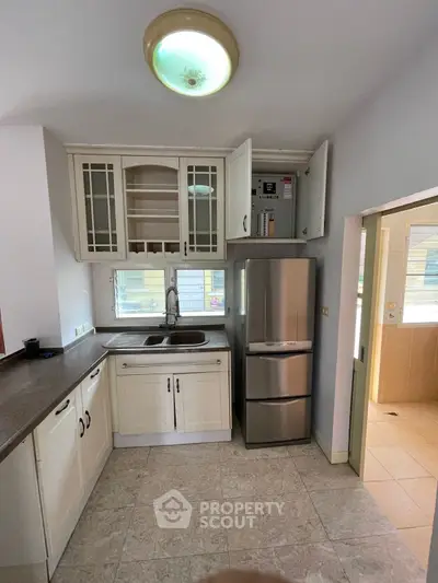 Spacious kitchen with modern fridge and ample cabinet storage