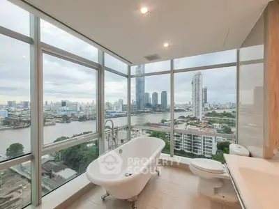 Luxurious bathroom with stunning city view and freestanding bathtub in high-rise apartment.