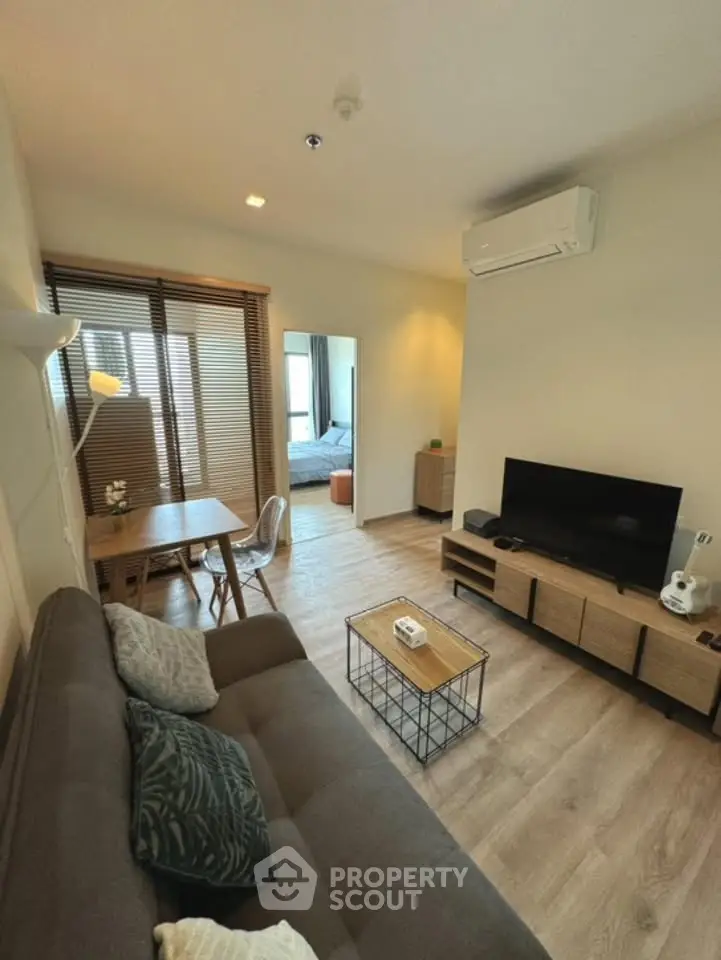 Modern living room with stylish decor and open layout, featuring a cozy sofa and entertainment center.