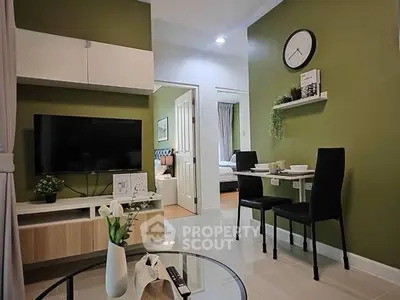 Modern living room with green walls, wall-mounted TV, and dining area