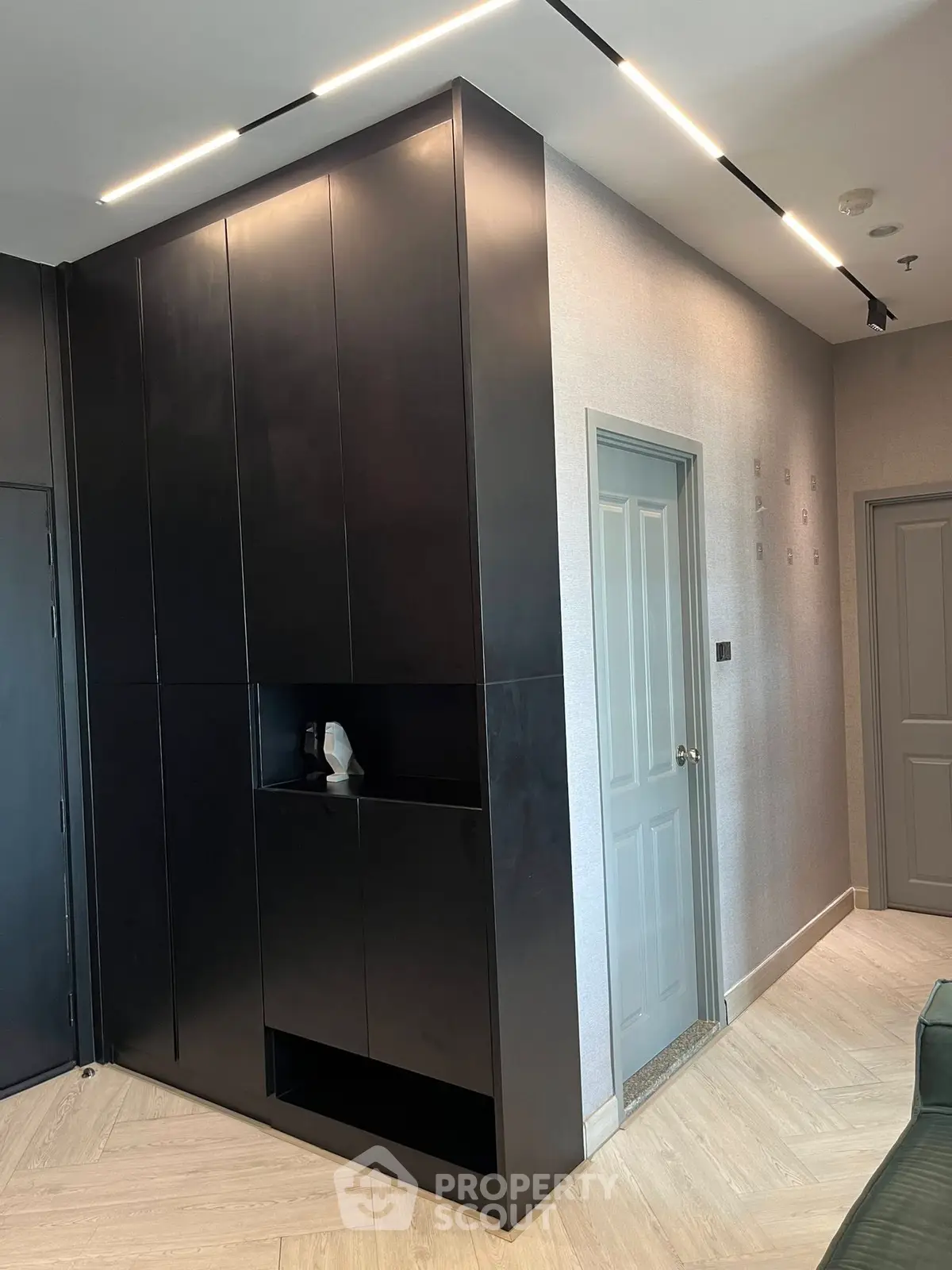 Modern interior with sleek black cabinetry and stylish lighting in a contemporary apartment.
