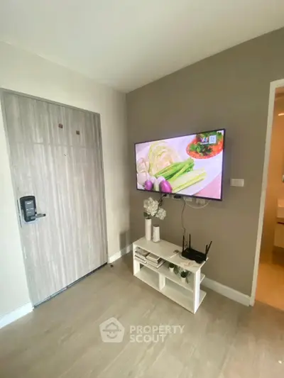 Modern living room with wall-mounted TV and stylish decor in a cozy apartment.