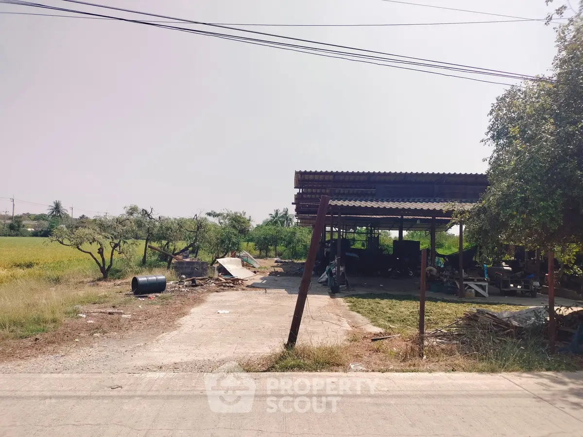 Rural property with open structure and surrounding greenery, ideal for agricultural use or development.