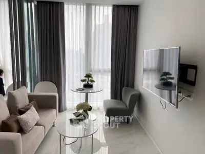 Modern living room with sleek furniture and large windows offering natural light.