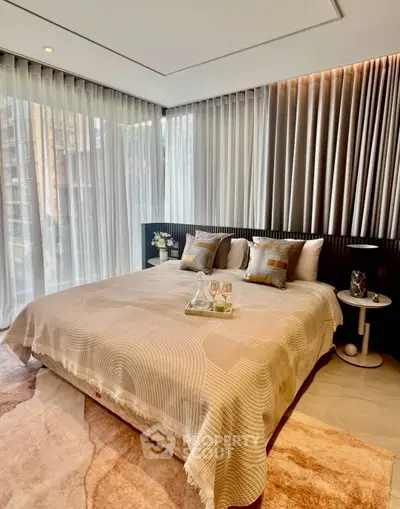 Luxurious bedroom with elegant decor and floor-to-ceiling windows in modern apartment.