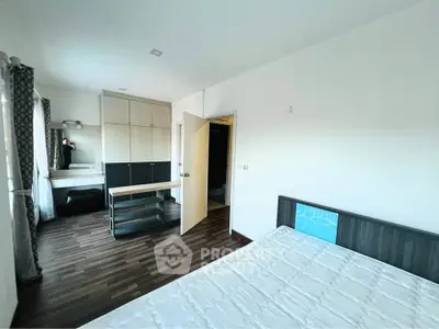 Spacious bedroom with modern furnishings and ample natural light, featuring sleek wooden flooring and built-in wardrobe.