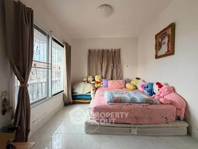 Cozy bedroom with plush toys and large window for natural light