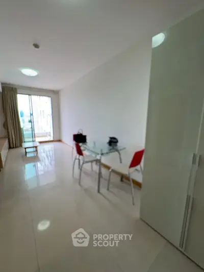Spacious modern living room with glass dining table and balcony access