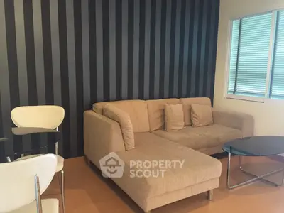 Modern living room with stylish striped wall and cozy beige sofa