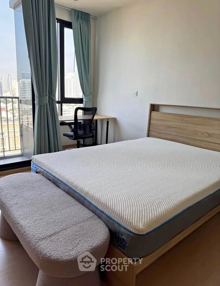 Modern bedroom with city view, featuring a comfortable bed and stylish decor.