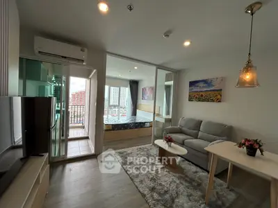 Modern open-plan living room with balcony and bedroom view