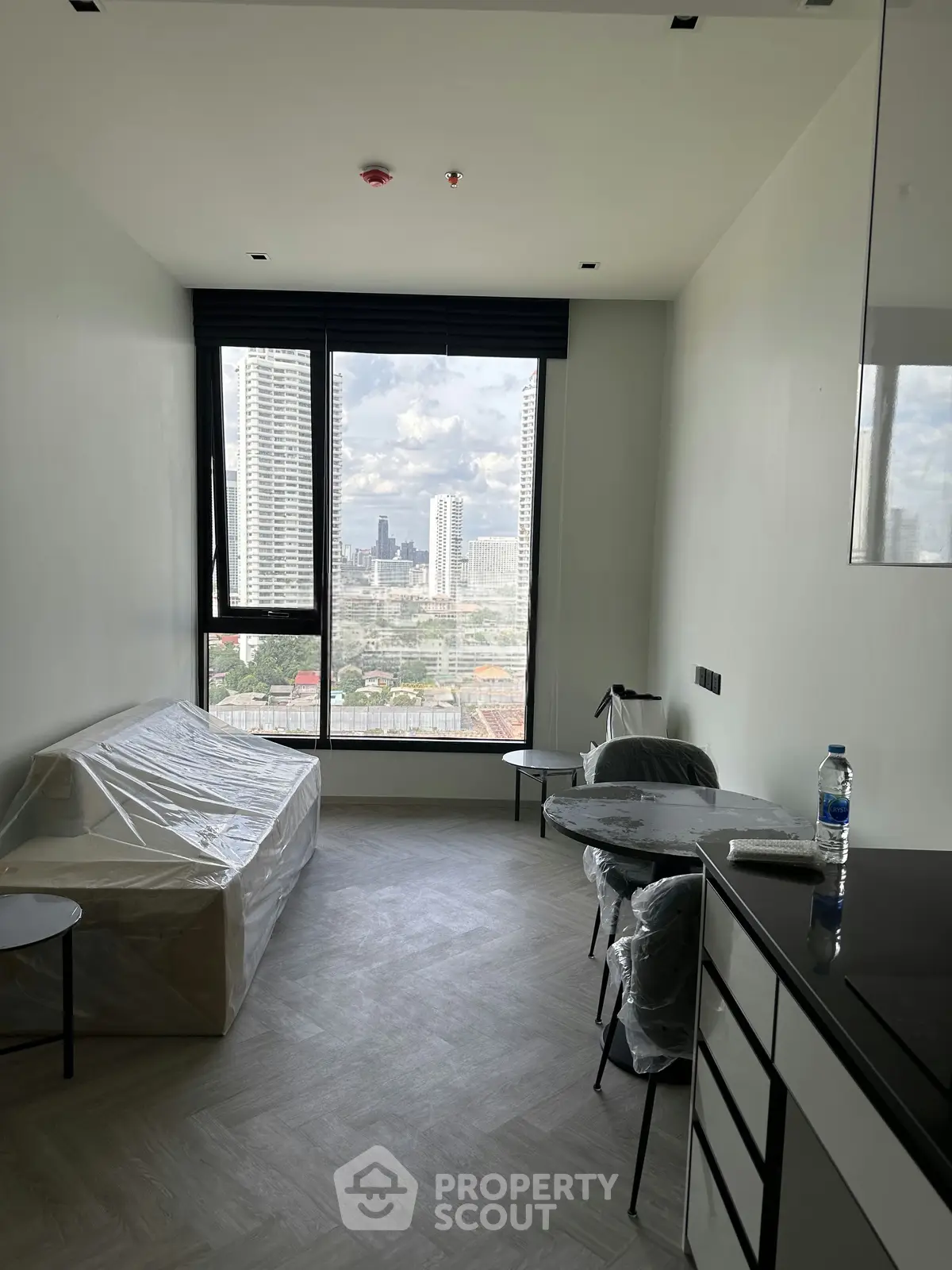 Modern apartment with city view, featuring a cozy living area and large windows for natural light.