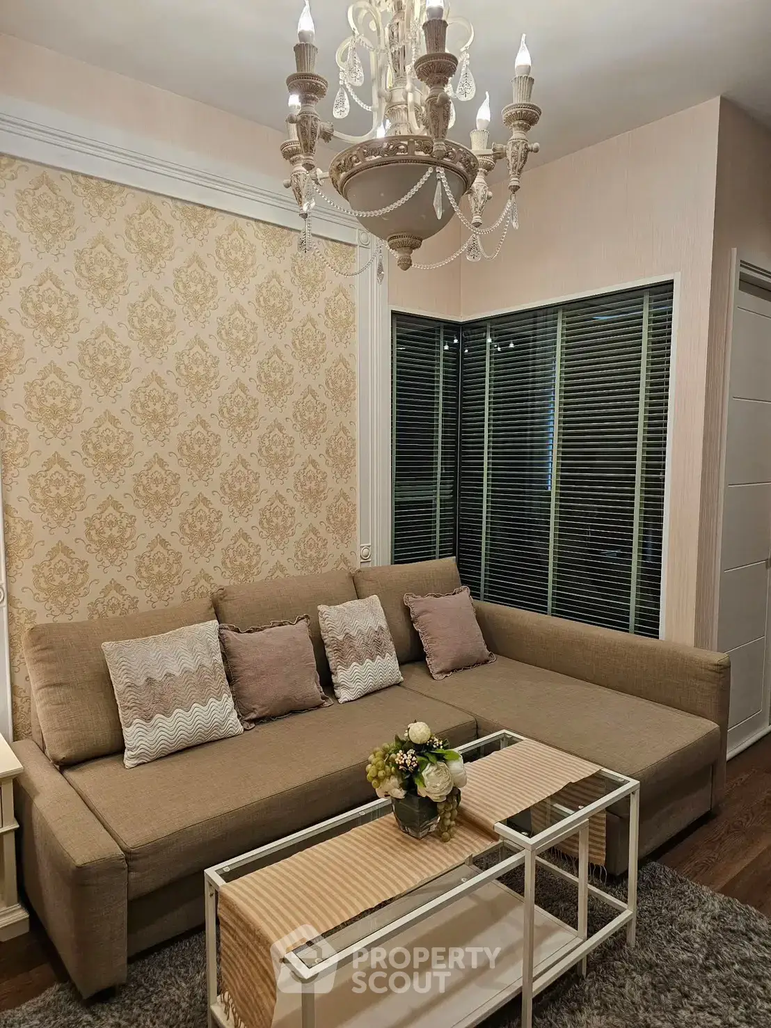 Elegant living room with chandelier and stylish sofa in cozy apartment