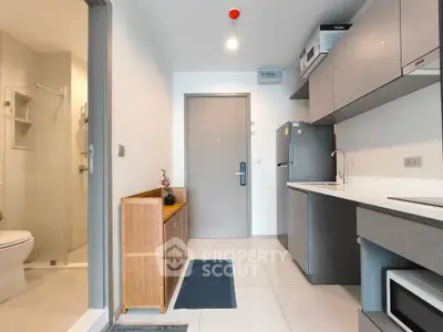 Modern apartment entrance with sleek kitchen and bathroom view