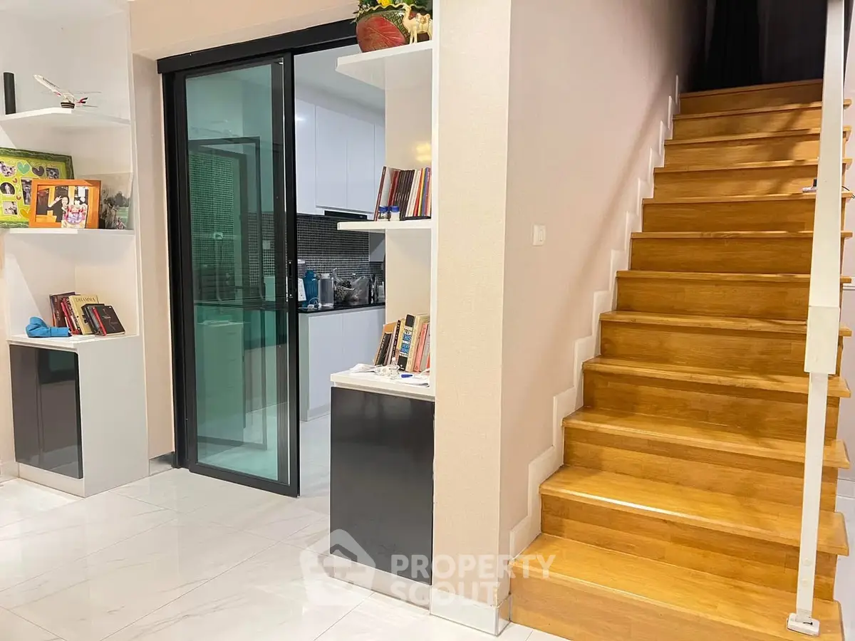 Modern home interior with wooden staircase and sleek kitchen design