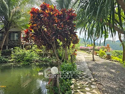 Lush garden with pond and scenic mountain view, perfect for tranquil living.