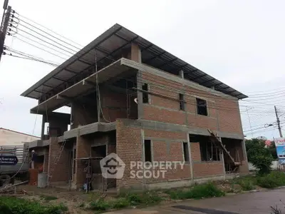 Under-construction brick building with modern design and open framework, ideal for customization.