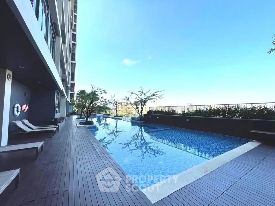 Luxurious modern apartment pool with stunning city view and sleek wooden deck.