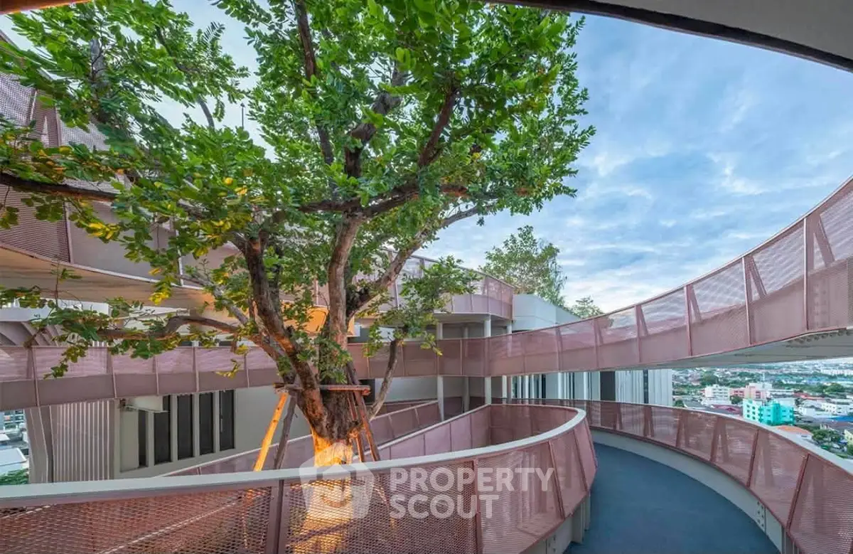 Stunning architectural design with tree integrated into modern building exterior, offering panoramic city views.