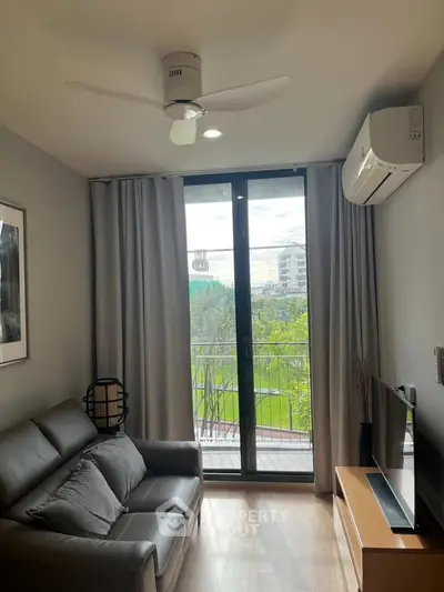 Modern living room with balcony view, featuring sleek furniture and air conditioning.