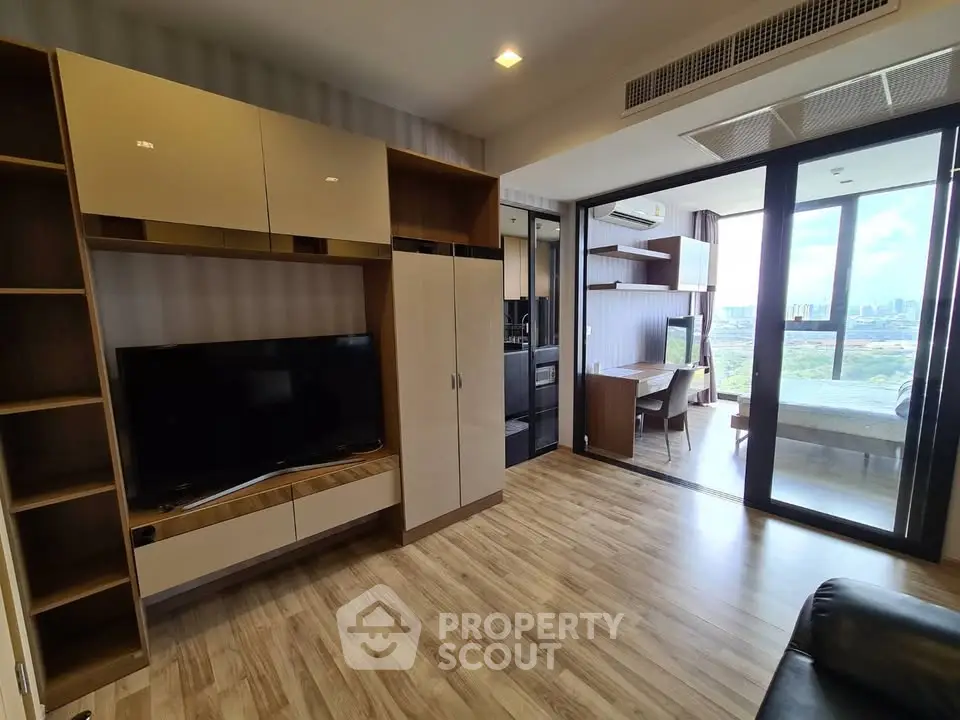 Modern living room with wooden flooring and large windows offering city views.