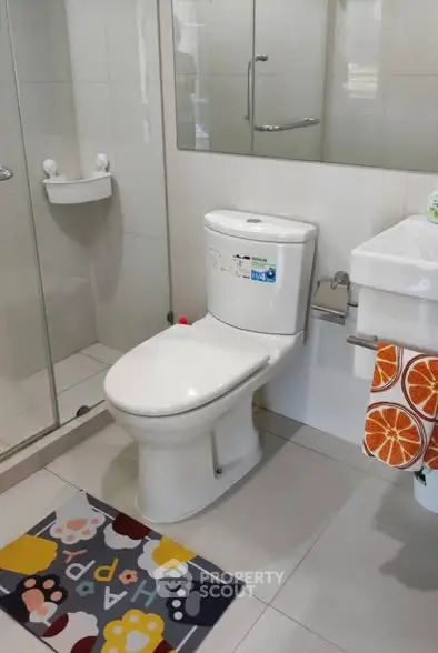 Modern bathroom with glass shower and colorful mat
