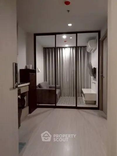 Modern apartment interior with glass partition and cozy living area.