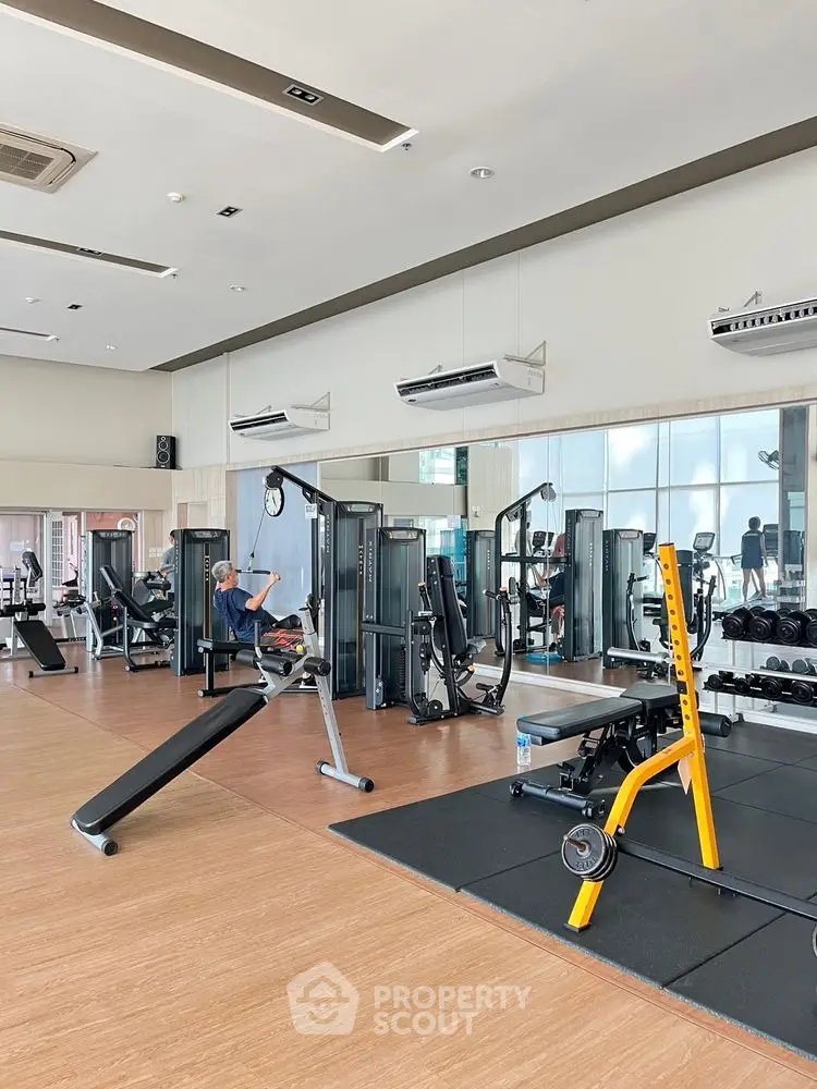 Spacious modern gym with state-of-the-art fitness equipment and mirrored walls.