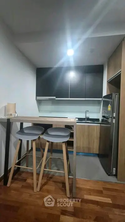 Modern kitchen with sleek cabinets and breakfast bar in contemporary apartment.