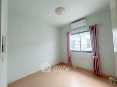 Bright empty bedroom with air conditioning and pink curtains, ready for personalization.