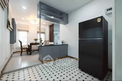 Modern kitchen with sleek black fridge and elegant dining area in open layout