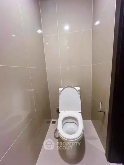 Modern bathroom with sleek tile design and contemporary toilet fixture.