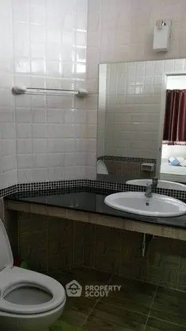 Modern bathroom with sleek sink and tiled walls, perfect for a contemporary home.