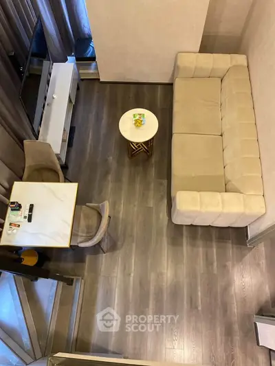 Modern living room with stylish furniture and wooden flooring, featuring a cozy sofa and dining area.