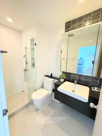 Modern bathroom with sleek design, glass shower, and stylish fixtures in a contemporary home.