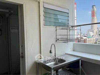 Charming balcony with city view and stainless steel sink, perfect for urban living.