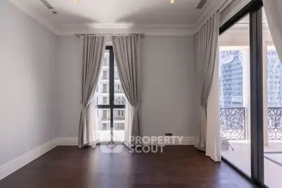 Spacious room with elegant curtains and balcony access in a modern apartment.