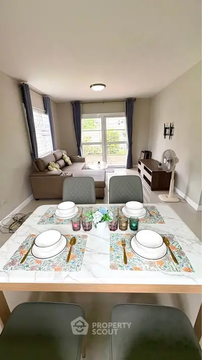 Cozy living room with dining area, modern decor, and large windows for natural light.