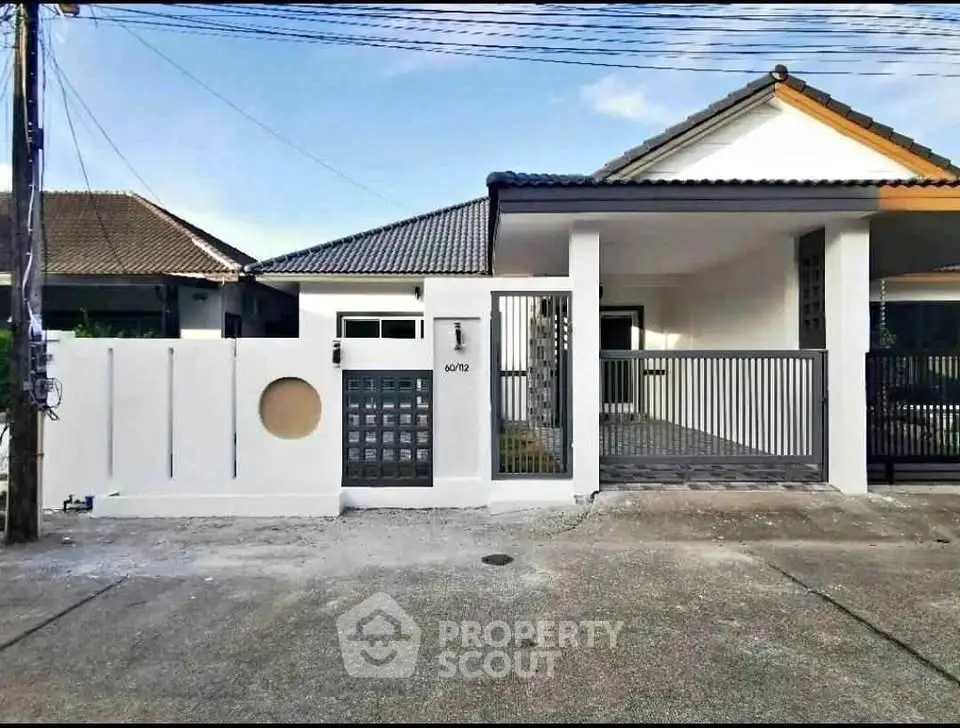 Charming single-story home with modern facade and gated entrance in a serene neighborhood.