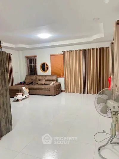 Spacious living room with modern sofa and elegant curtains