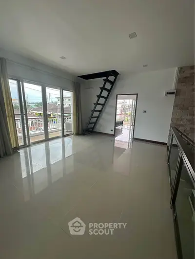 Spacious modern living room with large windows and balcony access
