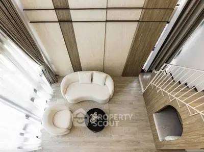 Elegant living room with modern furniture and high ceilings, featuring a cozy seating area and stylish decor.