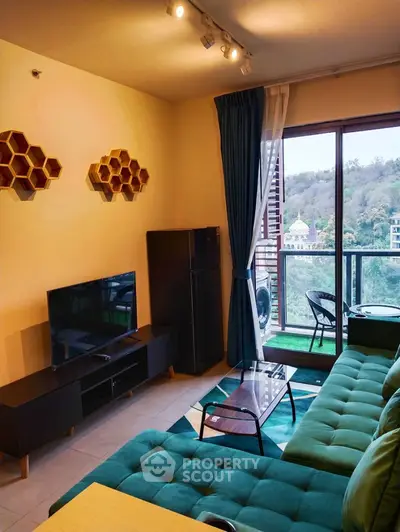 Stylish living room with green sofa and balcony view in modern apartment